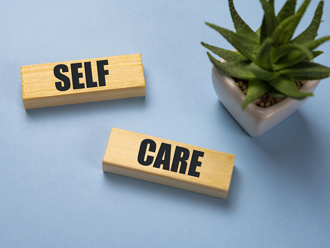 Self-care word on lightbox on blue background flat lay. Take care of yourself.